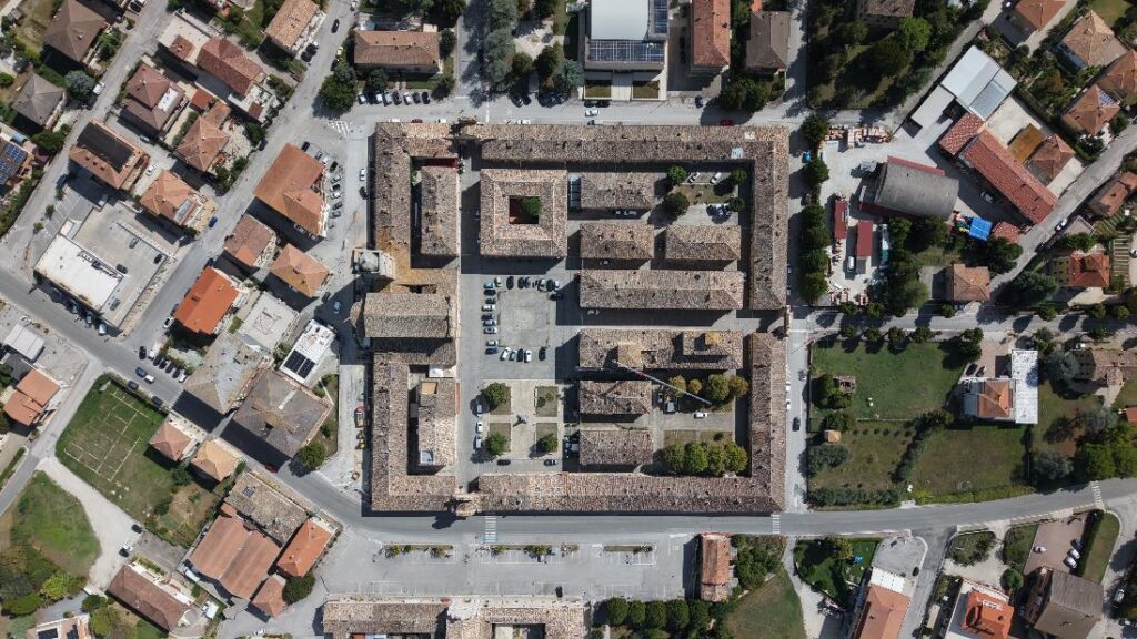Vista dall’alto, rivela la sua straordinaria pianta a quadrilatero perfetto (137x144 metri), progettata nel 1771 dall'architetto Virginio Bracci su commissione di Papa Clemente XIV. Un capolavoro di simmetria, proporzione e urbanistica neoclassica immerso nelle Marche.